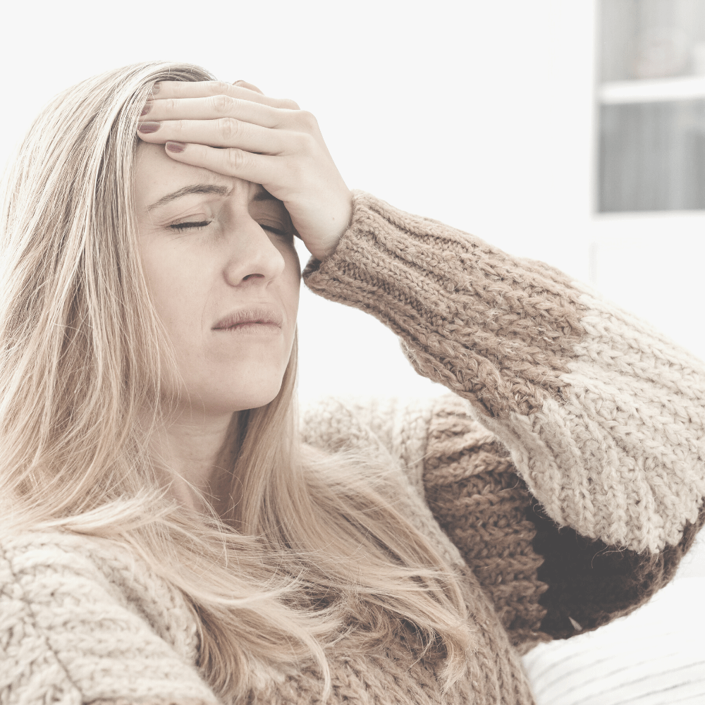 Kopfschmerztag: Frau mit Kopfschmerzen, hält sich den schmerzenden Kopf