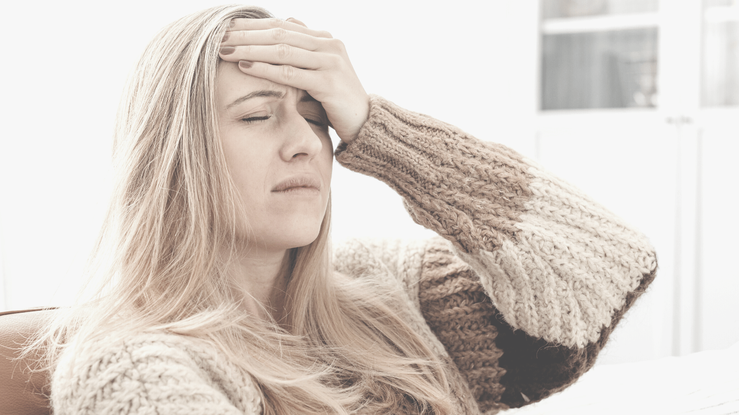 Kopfschmerztag: Frau mit Kopfschmerzen, hält sich den schmerzenden Kopf